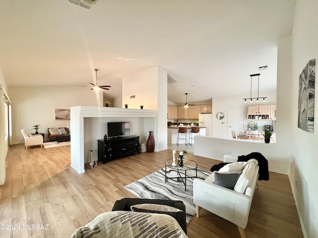 living room with vaulted ceiling, light wood-style floors, visible vents, and ceiling fan