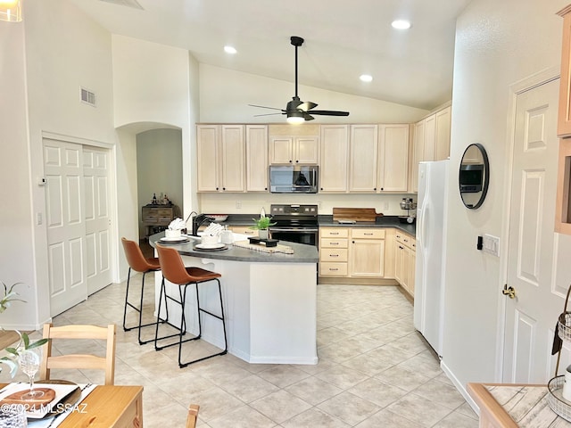 kitchen with light tile patterned flooring, a breakfast bar, lofted ceiling, ceiling fan, and stainless steel appliances