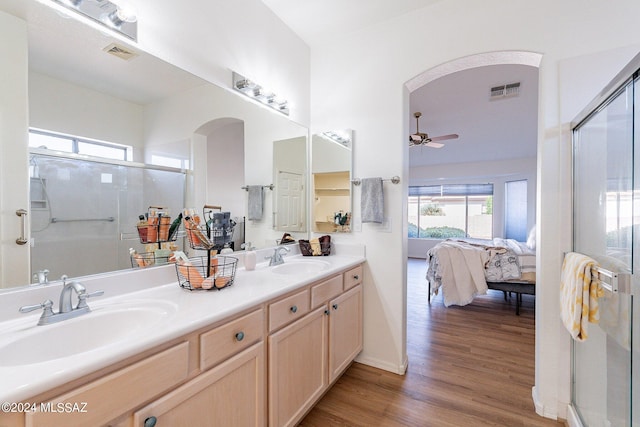 ensuite bathroom featuring a sink, visible vents, wood finished floors, and ensuite bath