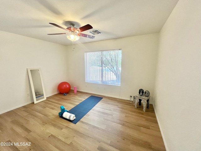 workout area featuring hardwood / wood-style floors and ceiling fan