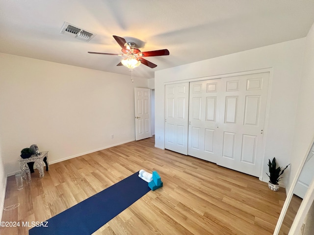 workout room with hardwood / wood-style flooring and ceiling fan