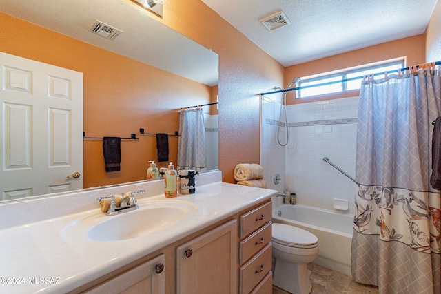 full bathroom featuring vanity, shower / tub combo with curtain, a textured ceiling, and toilet