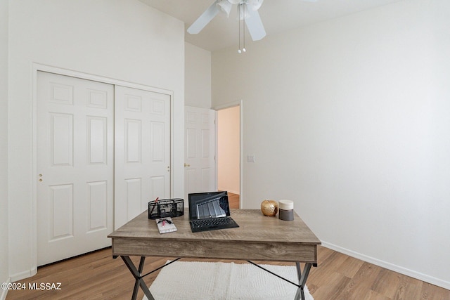 office featuring a ceiling fan, light wood-type flooring, and baseboards