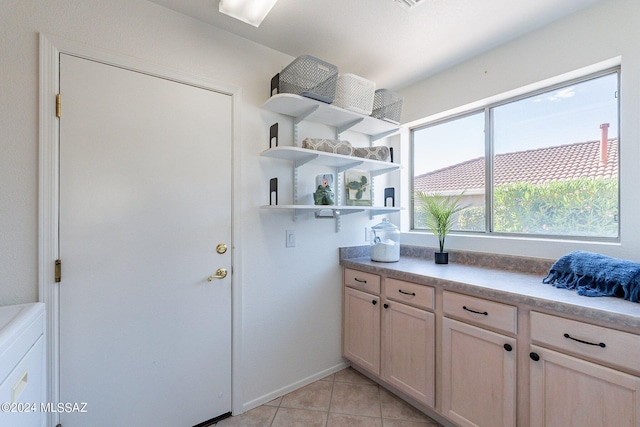 washroom with light tile patterned flooring and laundry area