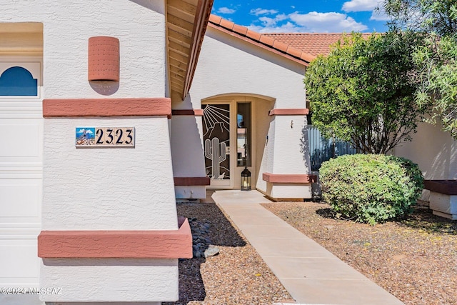 entrance to property with stucco siding and a tiled roof