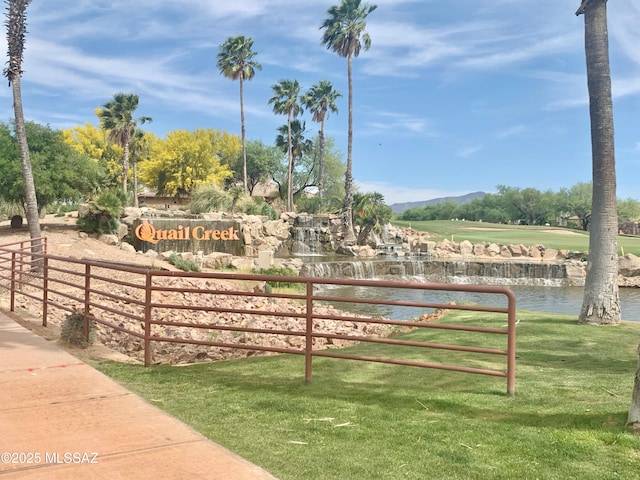 view of home's community featuring a water view and a lawn