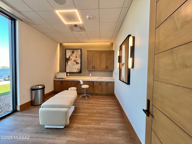 office space featuring wood finished floors, a healthy amount of sunlight, and baseboards