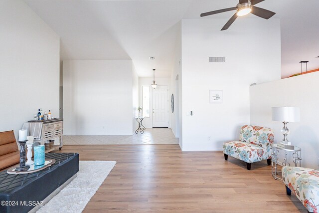 living room with lofted ceiling, light hardwood / wood-style flooring, and ceiling fan