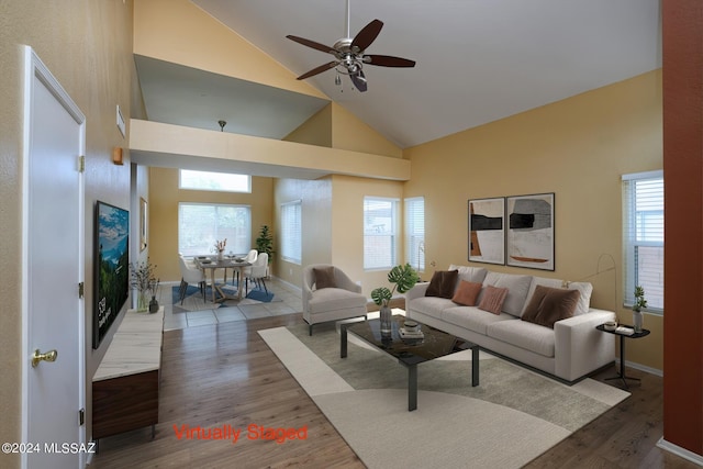 living room featuring hardwood / wood-style floors, high vaulted ceiling, and ceiling fan