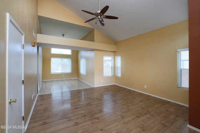 unfurnished room featuring hardwood / wood-style flooring, ceiling fan, and high vaulted ceiling