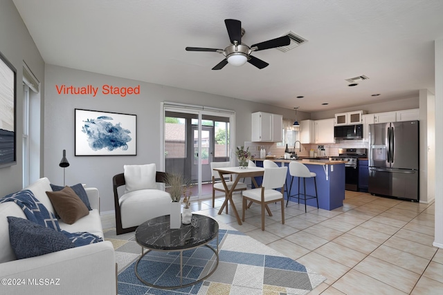 tiled living room featuring ceiling fan and sink