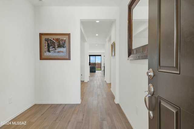 hallway with light hardwood / wood-style floors