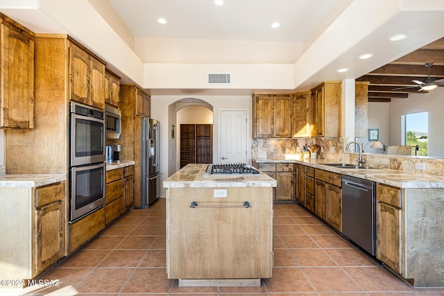 kitchen featuring beamed ceiling, decorative backsplash, a kitchen island, dark tile patterned flooring, and appliances with stainless steel finishes