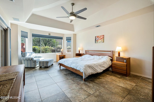 bedroom with ceiling fan and a tray ceiling