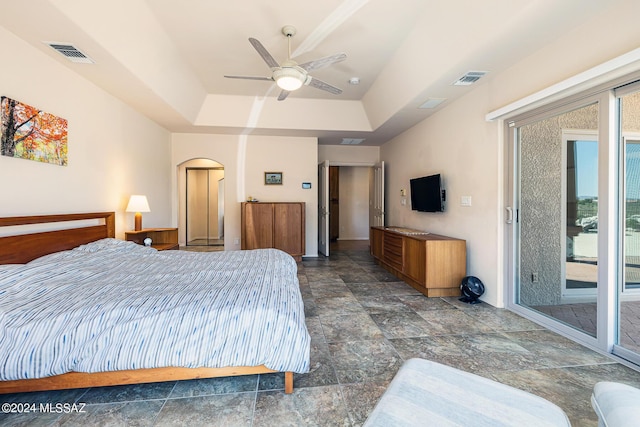 bedroom featuring a raised ceiling, access to exterior, and ceiling fan