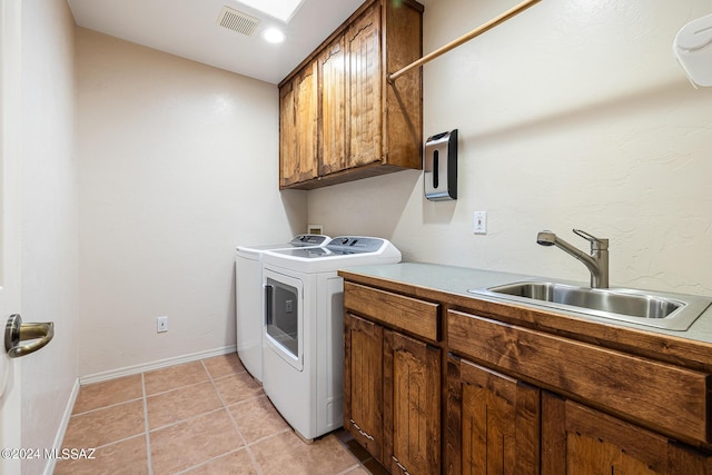 clothes washing area featuring washer and dryer, cabinets, light tile patterned floors, and sink