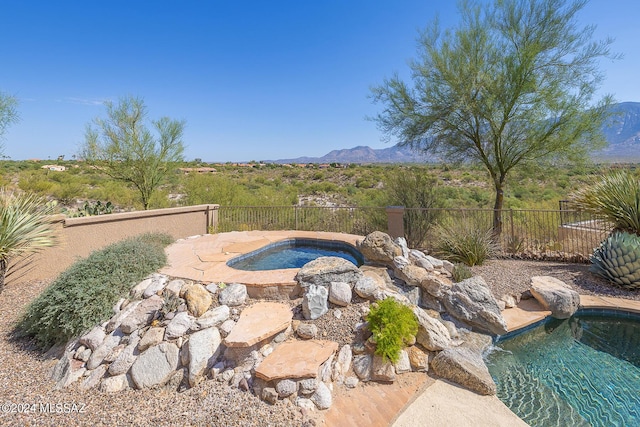 view of swimming pool featuring a mountain view and a hot tub