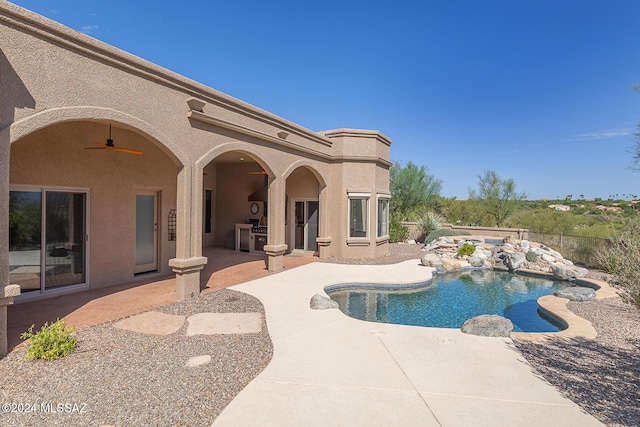 view of pool with ceiling fan, a patio area, and exterior kitchen