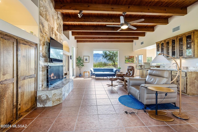 living room featuring tile patterned floors, ceiling fan, beam ceiling, and wooden ceiling