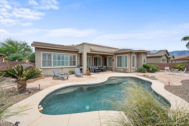 back of property with a fenced in pool and a patio area