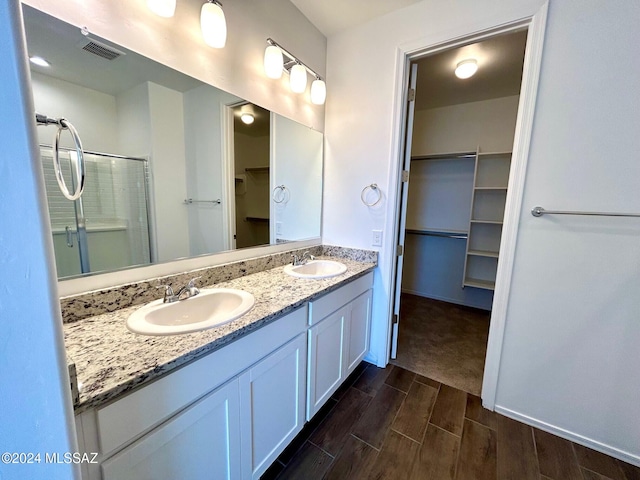 bathroom with vanity, wood-type flooring, and walk in shower