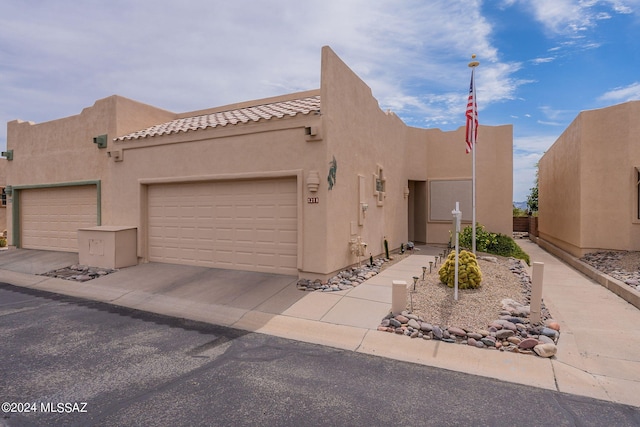 pueblo-style home with a garage