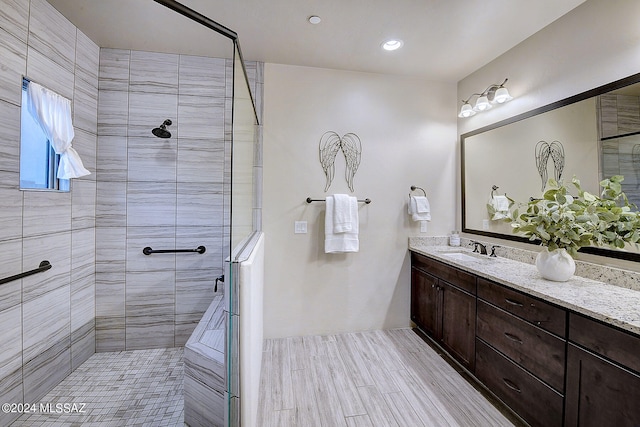 bathroom with vanity with extensive cabinet space and an enclosed shower