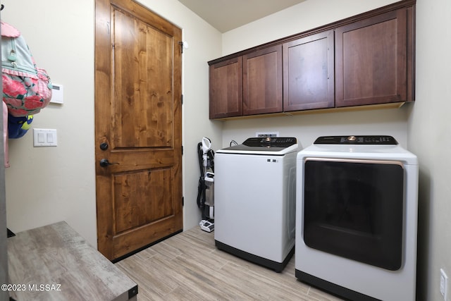 laundry area featuring washer and dryer, washer hookup, light wood-type flooring, and cabinets