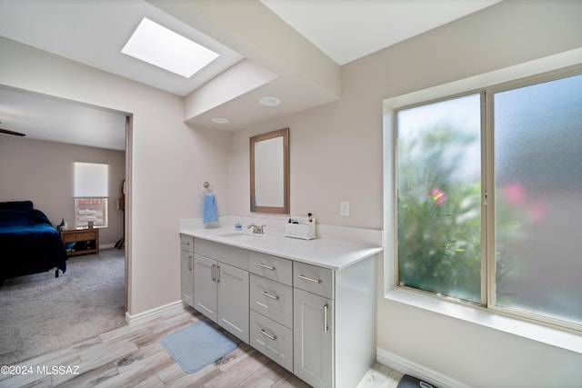 bathroom with vanity, wood-type flooring, and a skylight