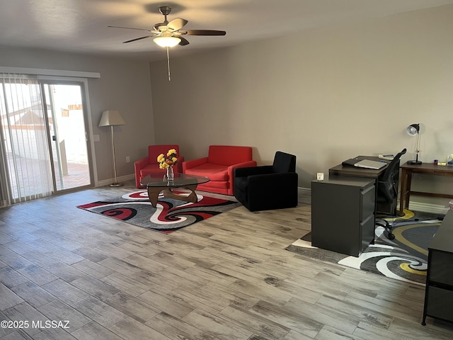 living room with ceiling fan and light hardwood / wood-style flooring