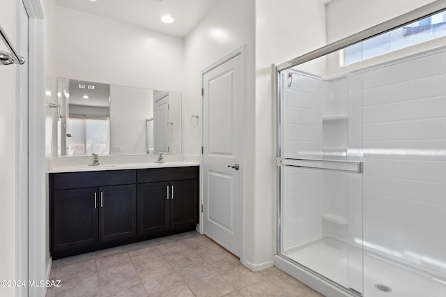 bathroom featuring a shower with door, tile flooring, and dual bowl vanity