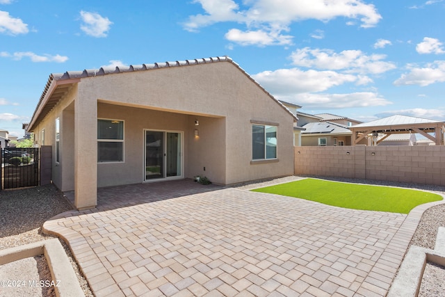 rear view of property with a gazebo and a patio area