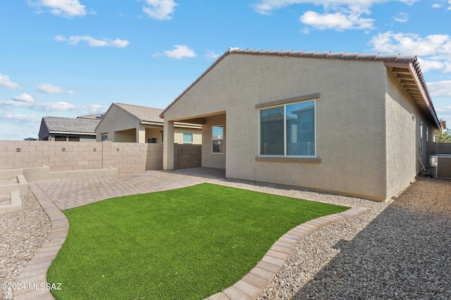 back of house with a patio area, central air condition unit, and a lawn