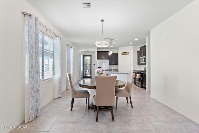 dining space featuring sink and light tile flooring