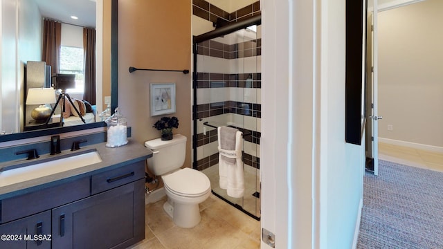 bathroom featuring tiled shower, tile patterned floors, vanity, and toilet