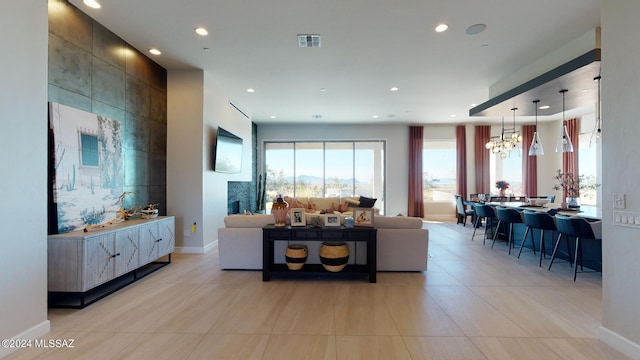 tiled living room featuring a tile fireplace and an inviting chandelier