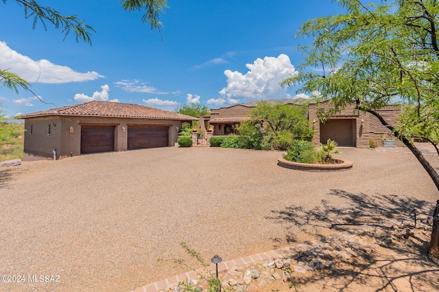 view of front of property featuring a garage, a tiled roof, and brick siding