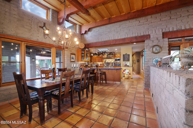 dining area with light tile patterned flooring, a high ceiling, a notable chandelier, wooden ceiling, and beamed ceiling