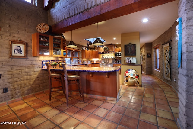 kitchen with light tile patterned floors, open shelves, a peninsula, and brick wall