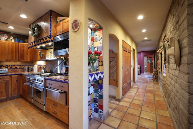 kitchen featuring visible vents, recessed lighting, arched walkways, a warming drawer, and stainless steel appliances