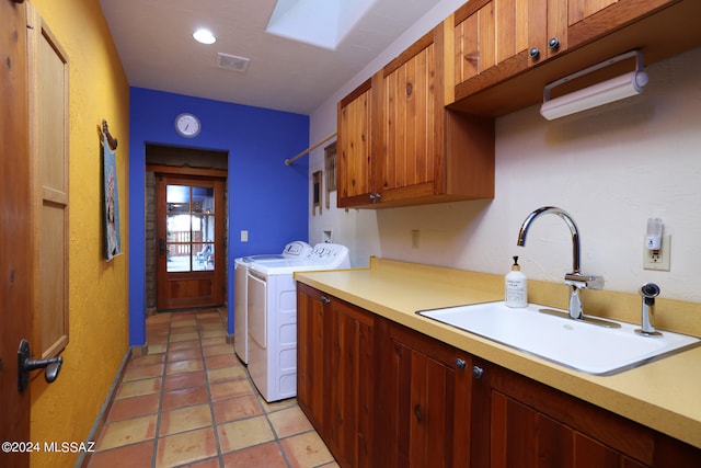 laundry room with visible vents, cabinet space, a sink, light tile patterned floors, and washer and dryer
