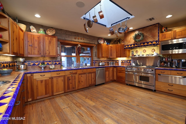 kitchen featuring open shelves, light wood-style flooring, stainless steel appliances, visible vents, and a warming drawer