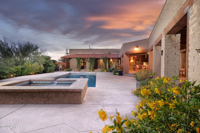 view of patio / terrace with an in ground hot tub and an outdoor pool