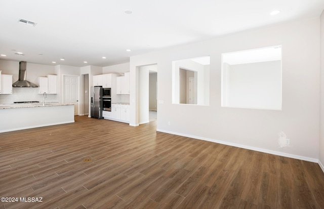 unfurnished living room with dark hardwood / wood-style floors and sink