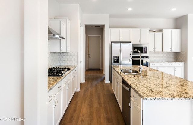 kitchen featuring an island with sink, decorative backsplash, dark hardwood / wood-style floors, white cabinetry, and appliances with stainless steel finishes