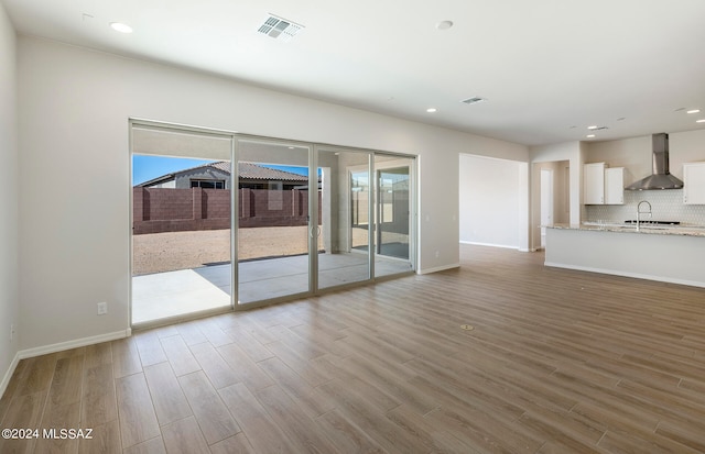 unfurnished living room with sink and light wood-type flooring