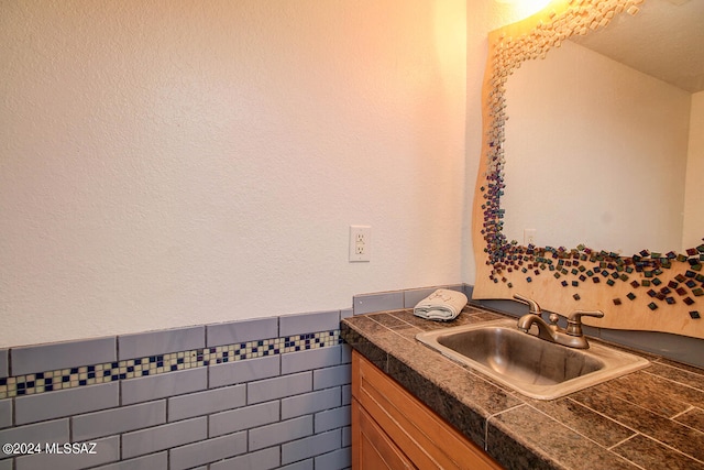 bathroom featuring vanity and tile walls