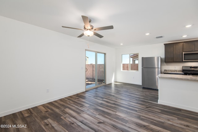 interior space featuring ceiling fan, dark brown cabinets, light stone countertops, stainless steel appliances, and dark hardwood / wood-style flooring