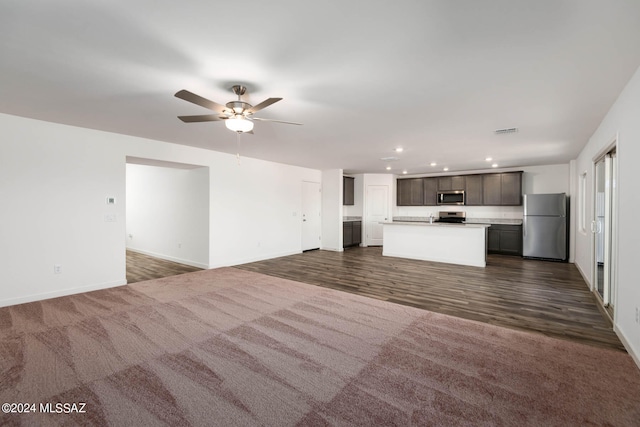 unfurnished living room with dark carpet and ceiling fan