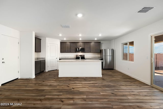 kitchen with dark brown cabinets, stainless steel appliances, dark hardwood / wood-style floors, and a center island with sink